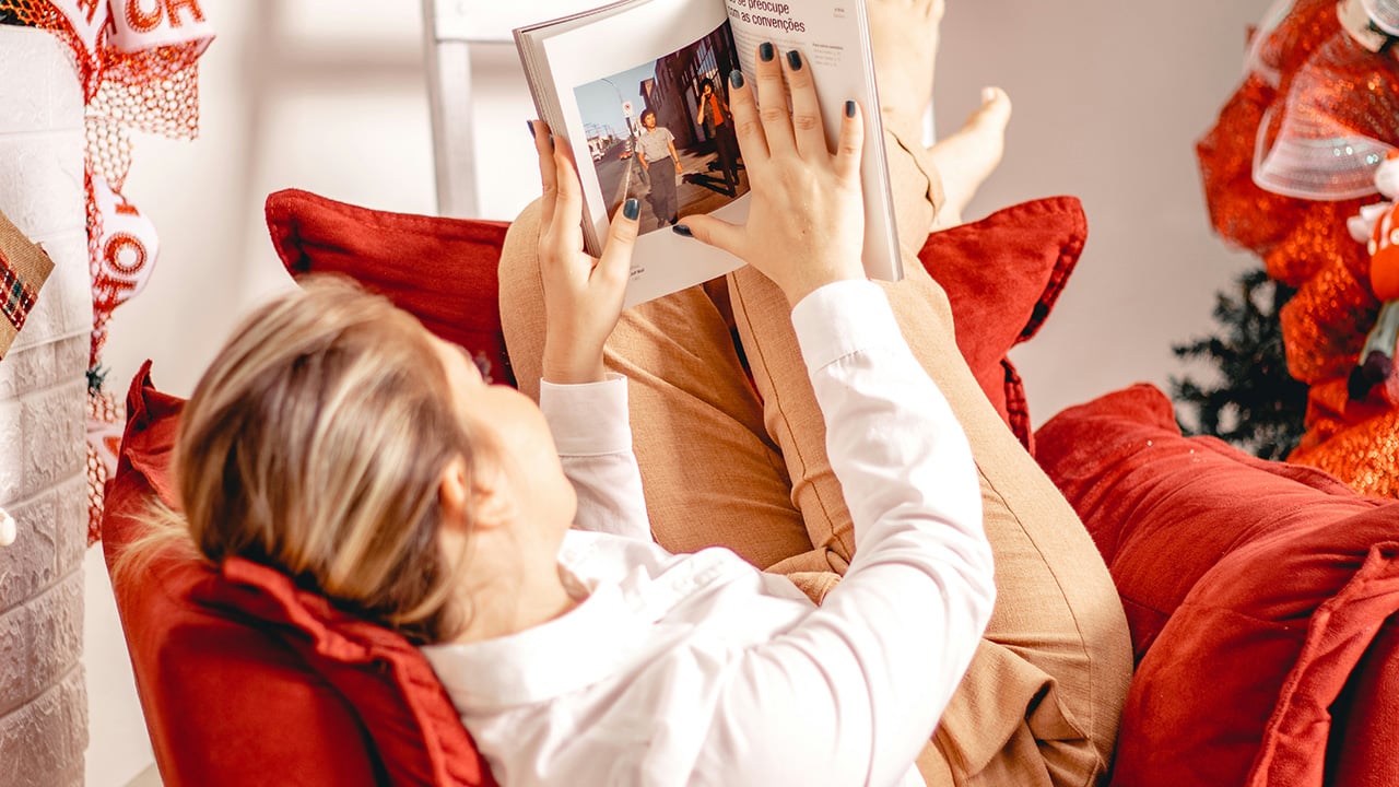 Lady reading a book on the couch.